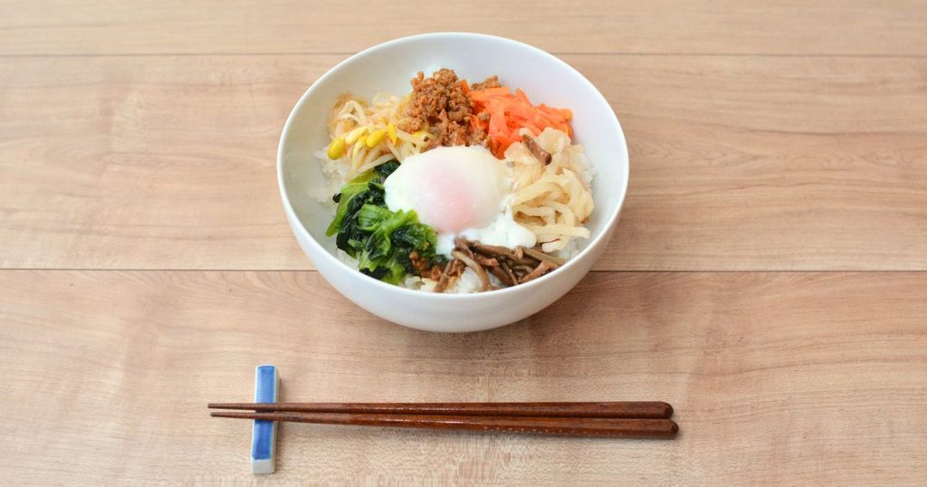 半熟玉子と5色のナムルを盛り付けたコープデリのビビンバ丼