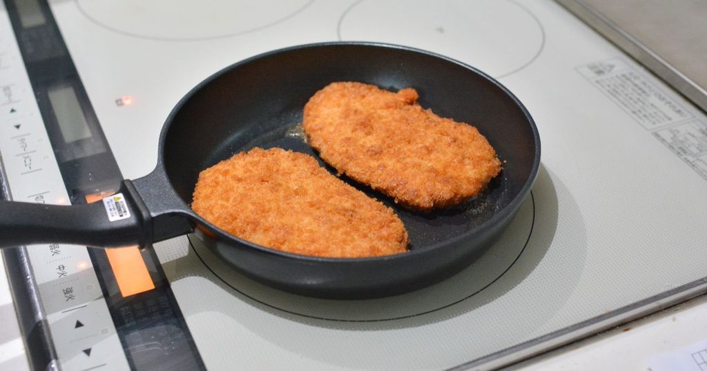 ミールキットのとんかつ2枚をフライパンで加熱しているところ
