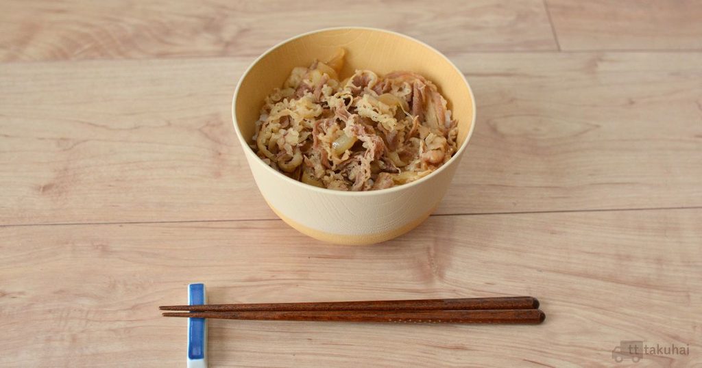 松屋の牛めしをご飯にのせ、黄色い器に盛り付けた様子