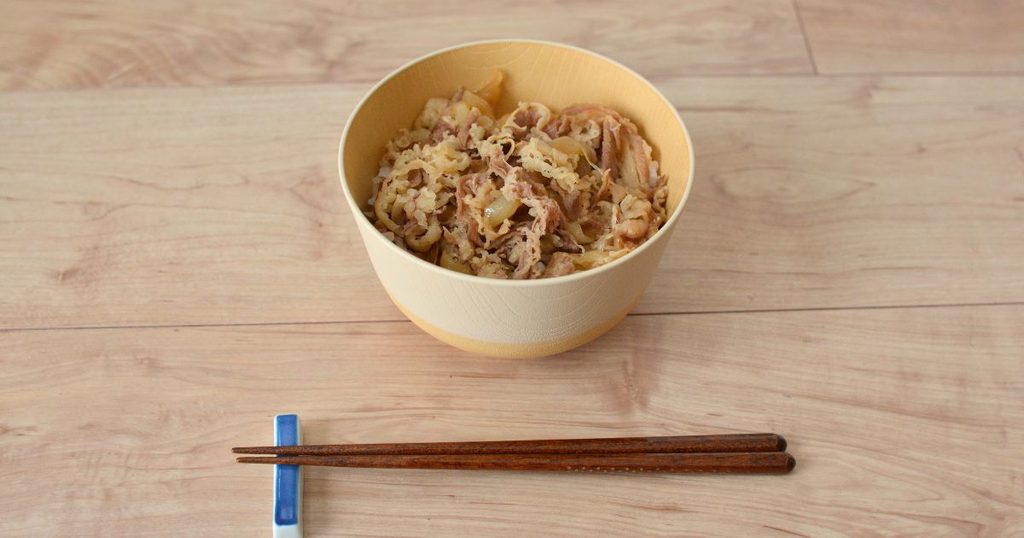 松屋の牛めしをご飯にのせ、黄色い器に盛り付けた様子
