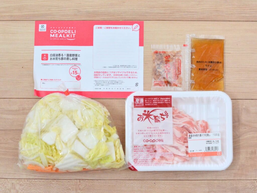 コープデリのミールキット「白醤油香る！国産野菜とお米育ち豚の蒸し料理」の届いた中身。カット済みの白菜とにんじん、豚肉、たれ、かつお節、レシピカード